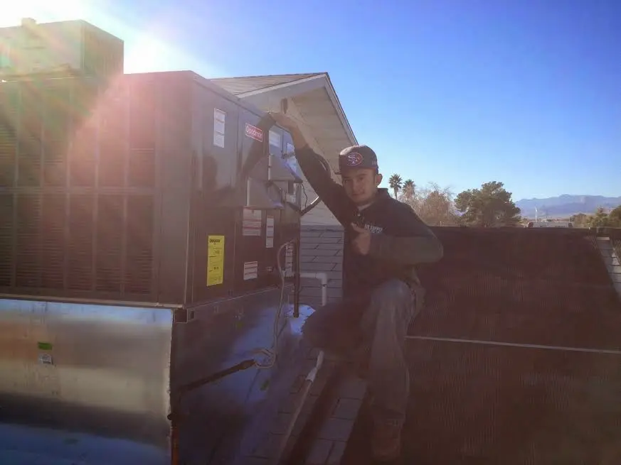 HVAC technician performing Air Duct Repair on a rooftop unit in Mankato